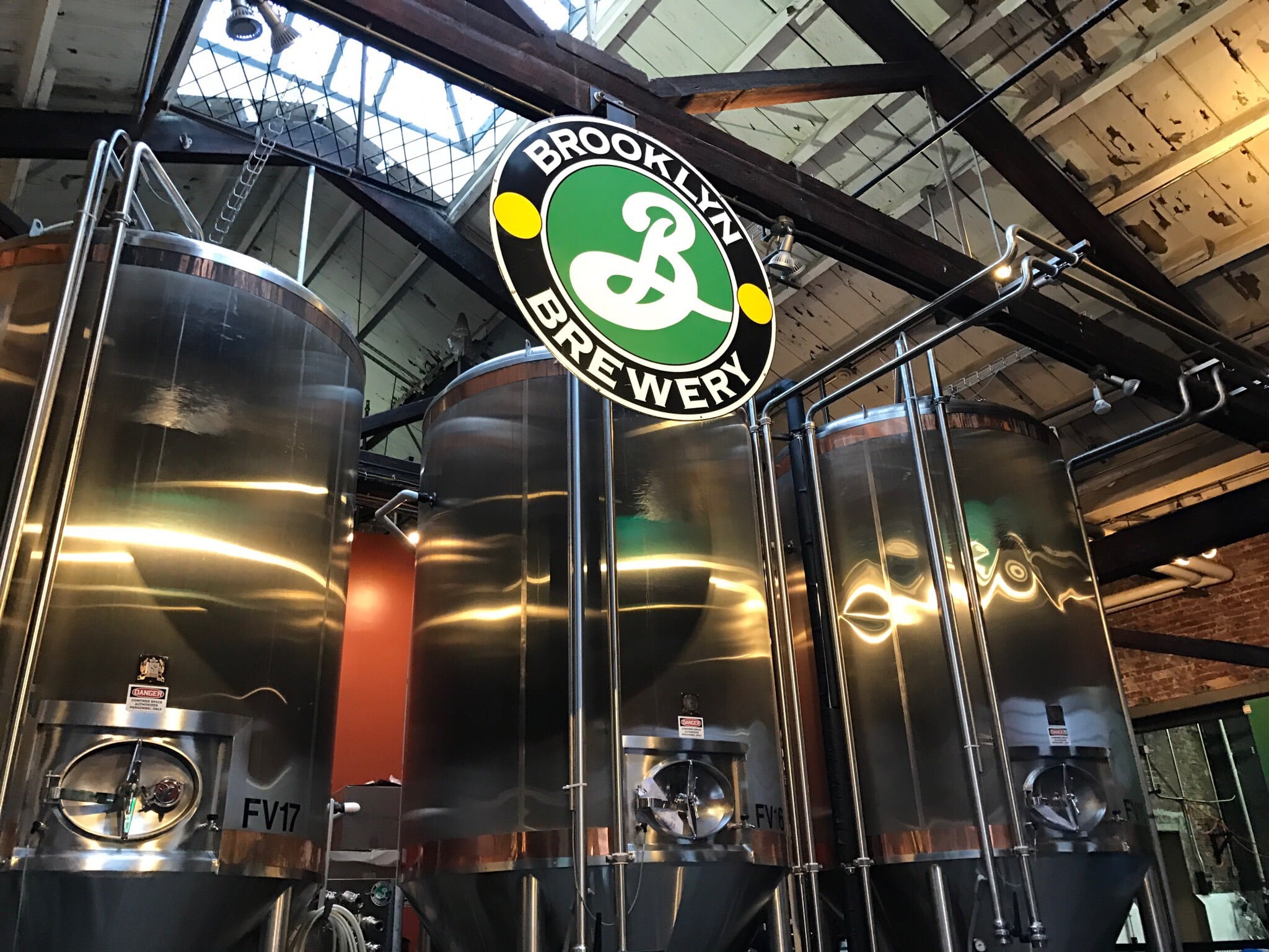 Interior da cervejaria Brooklyn Brewery, com vários tanques metálicos de grande dimensão.