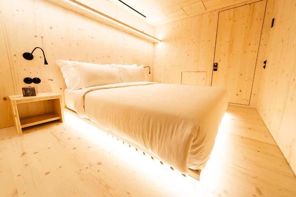 Quarto do Zero Box Lodge Porto com cama de casal e uma cómoda ao lado.
