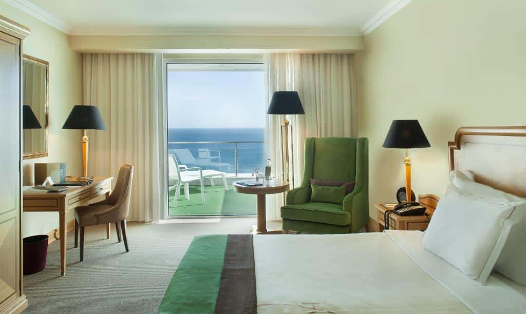 Quarto do Hotel Cascais Miragem Health & Spa, com cama de casal, cómoda e sofá.