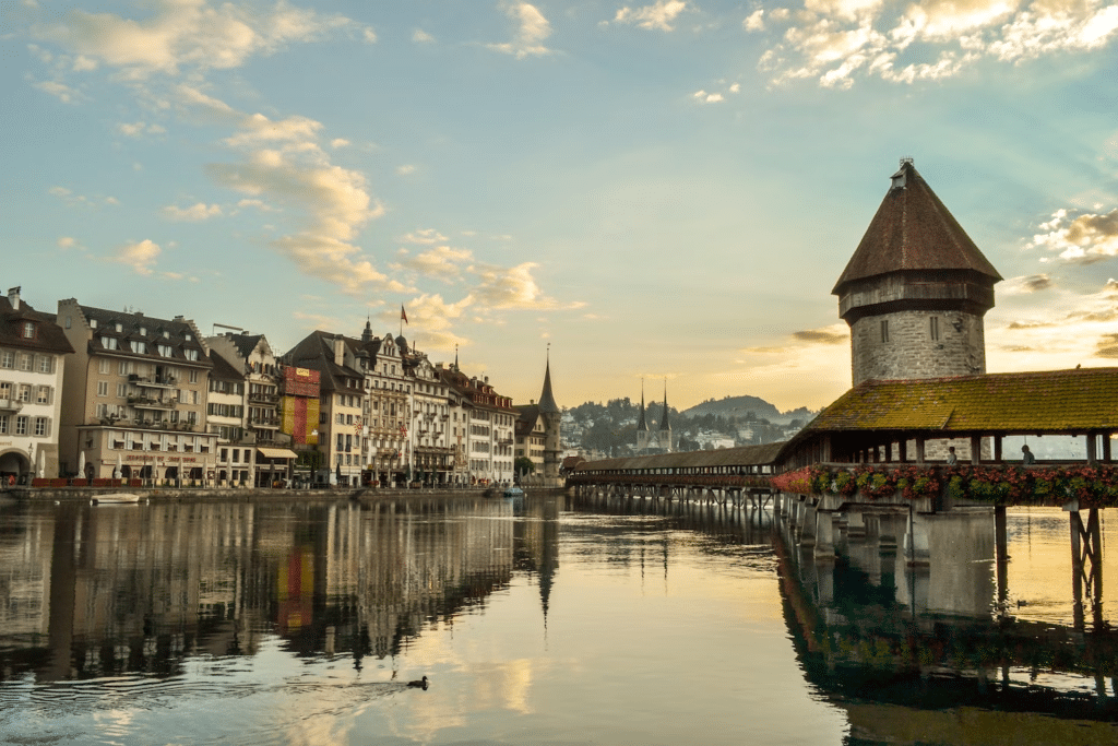 Vista da cidade de Lucerna, com a Ponte da Capela à direita, construções históricas e o rio Reuss.