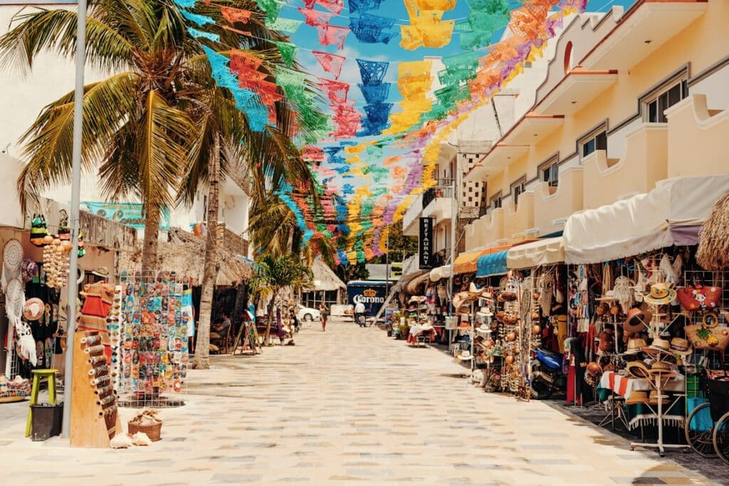 Quinta Avenida, em Playa del Carmen. É uma rua movimentada com lojas de artesanato e bandeirinhas coloridas ao longo de todo o caminho.