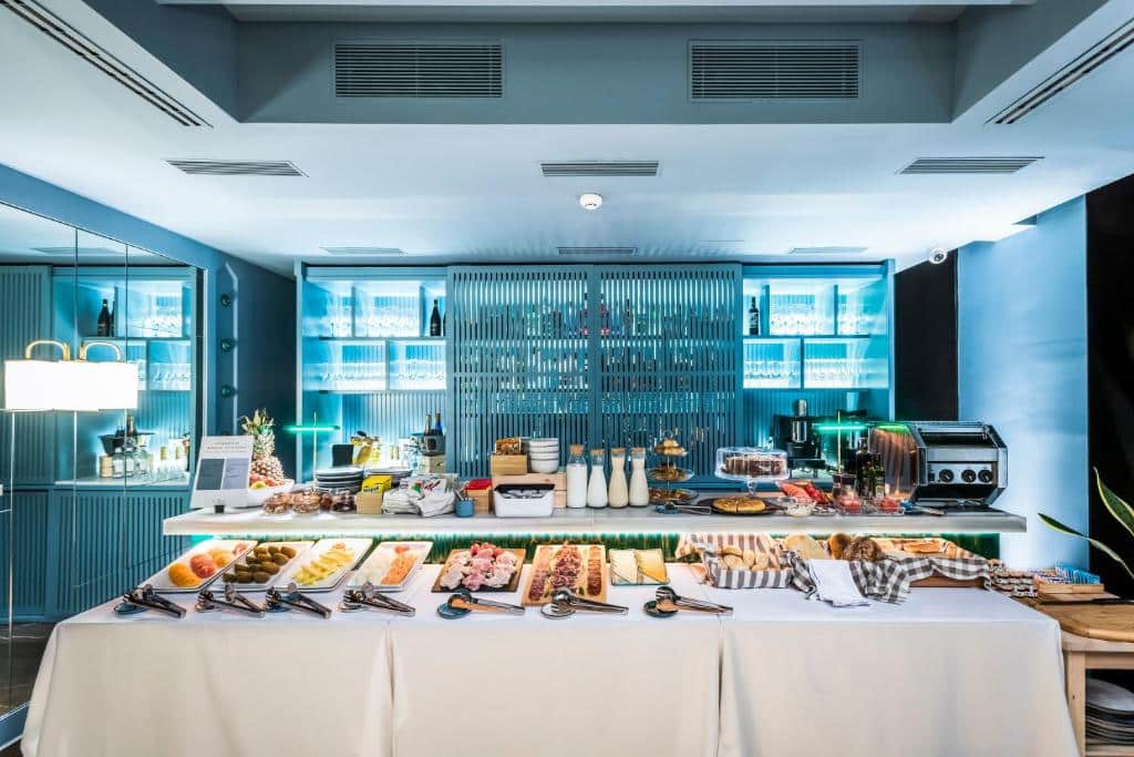 Pequeno-almoço do Hotel Casa de Indias By Intur com variedade de frios, pães, bebidas e máquina de café.