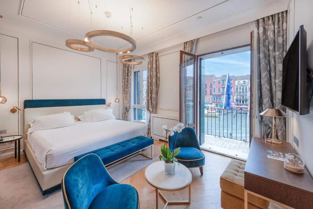 Quarto de hotel moderno com vista para os canais de Veneza, janelas amplas, iluminação elegante e mobiliário de design em tons de azul e branco