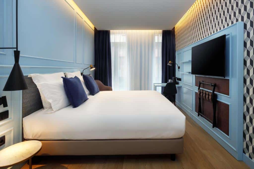 Quarto do Mercure Porto Centro Aliados com cama de casal e televisão na parede em frente.