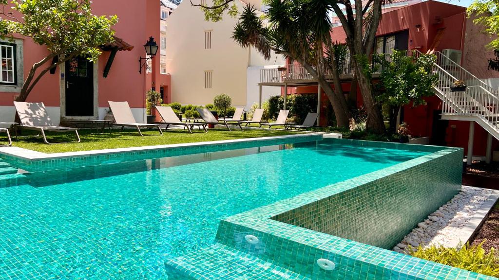 Piscina do Jardim da Lapa by Shiadu com deck em redor com relva, árvores e espreguiçadeiras