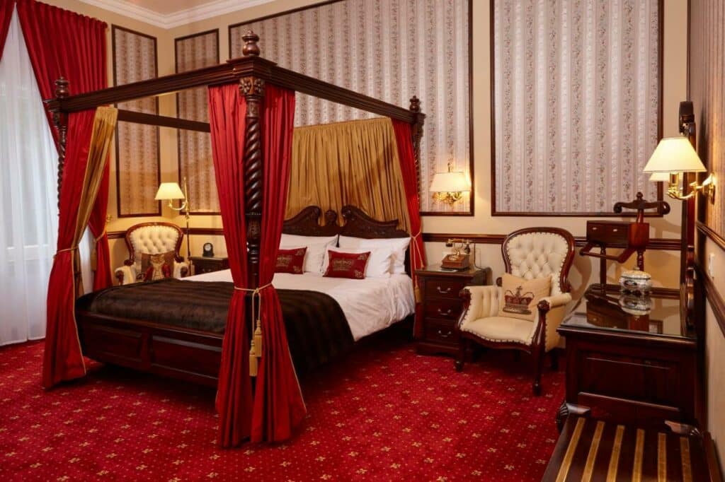 Quarto do Hotel Villa Achenbach com cama de casal e cómodas dos dois lados. Representa hotéis em Dusseldorf.
