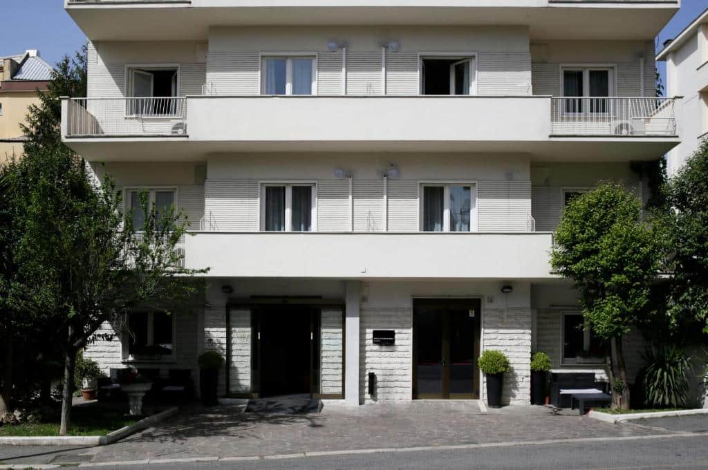 fachada do c-hotels Club House Roma com três andares em branco, acolhedora, com janelas e portas, algumas com varanda