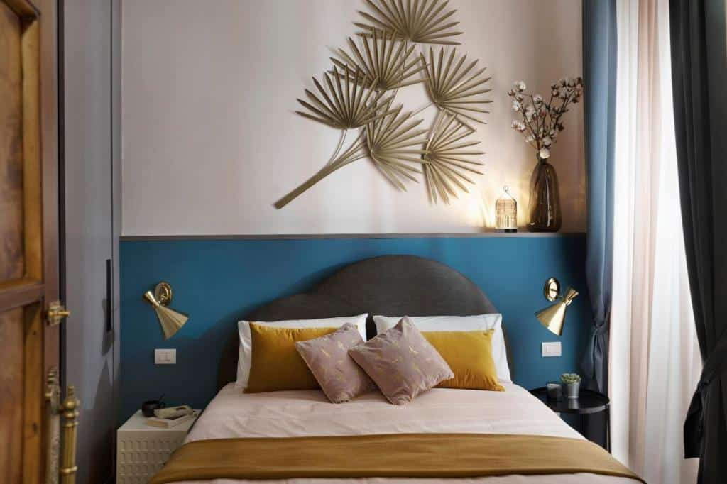 quarto do Luxury Trevi House, uma das opções de onde ficar em Roma, com cama de casal, candeeiros sobre as mesas de cabeceira de cada lado, decoração na parede e vasos de plantas, com uma janela de um lado e um roupeiro do outro