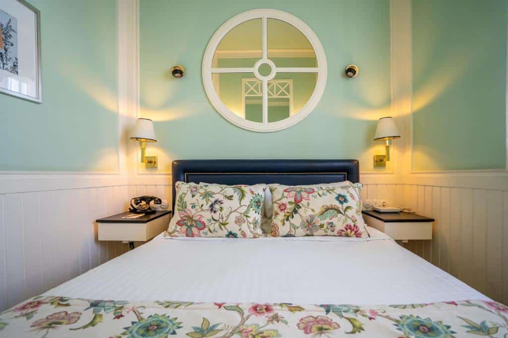 Quarto do Grande Hotel do Porto com cama de casal ao centro e mesinhas de cabeceira de cada lado.