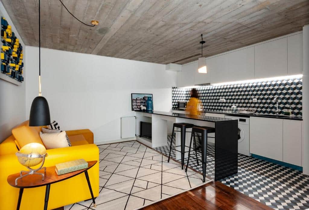 Sala do PortoSoul Trindade, com sofá à esquerda, um balcão em frente e, ao fundo, a cozinha.