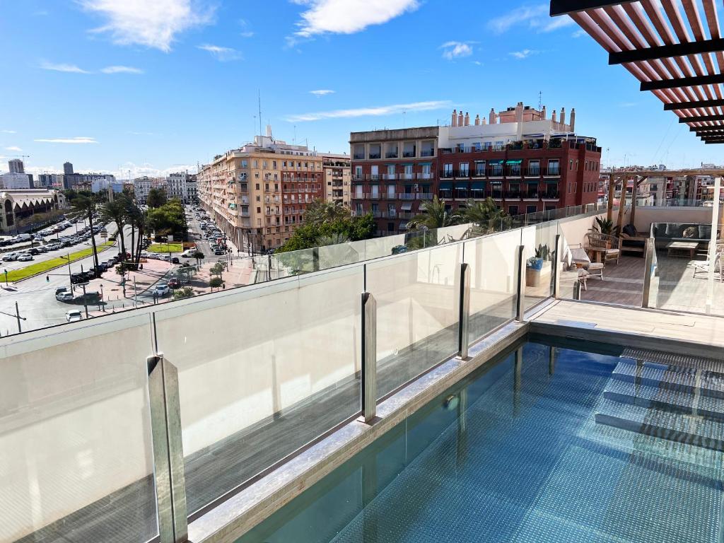 Edifícios de apartamentos do Valencia Luxury, com varandas, num centro urbano com ruas e passeios movimentados.