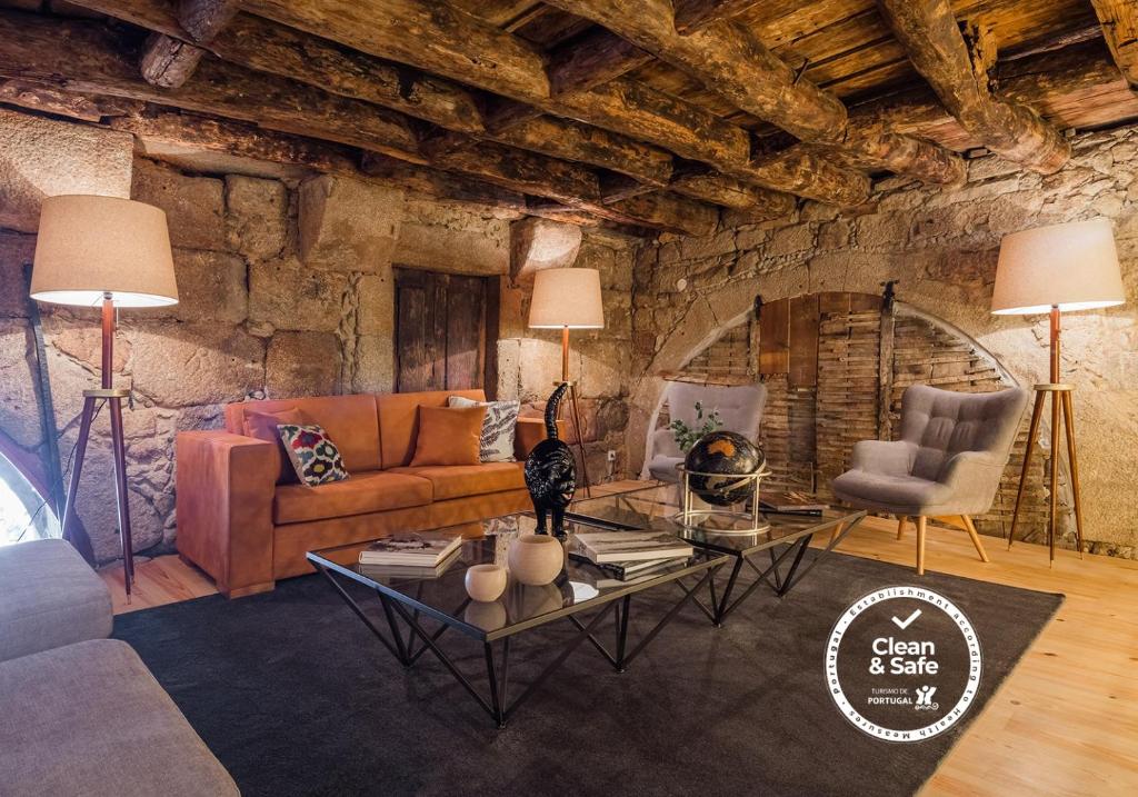 Sala de estar do Porto River, com sofá à esquerda e duas mesas de apoio em vidro à frente.