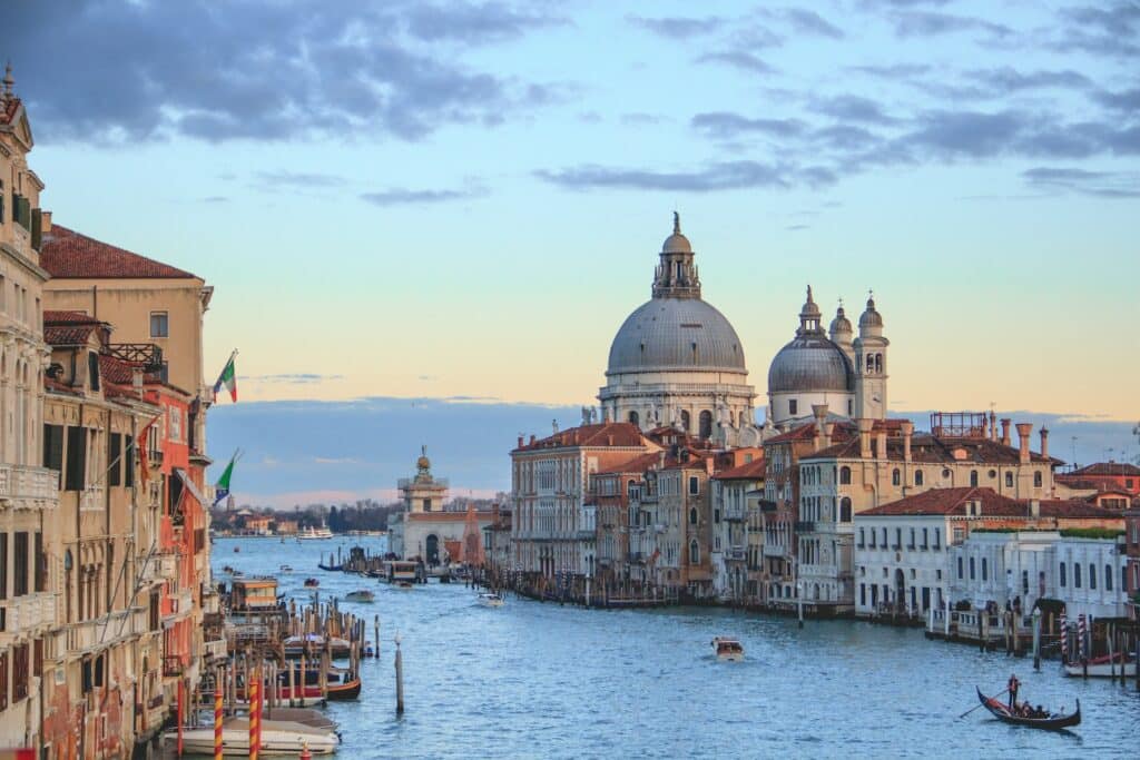 Canal de Veneza com algumas embarcações e muitos edifícios históricos