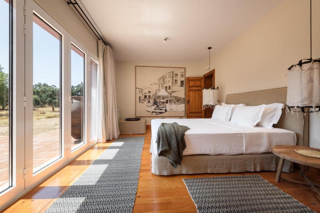 Quarto amplo da A Casa do Governador com cama de casal e portas de vidro a dar para o jardim