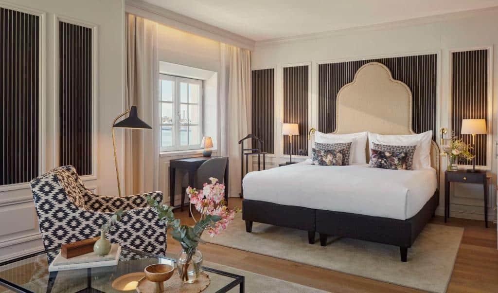 Quarto do Hôtel Reisen com poltrona, cama de casal e cómodas com candeeiros.