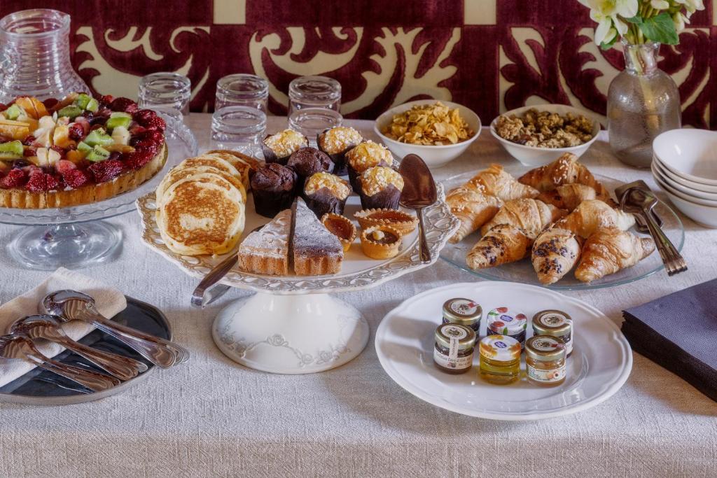 Bandeja com iguarias de pastelaria: bolos, tartes, pães, doces e sumos, num ambiente acolhedor