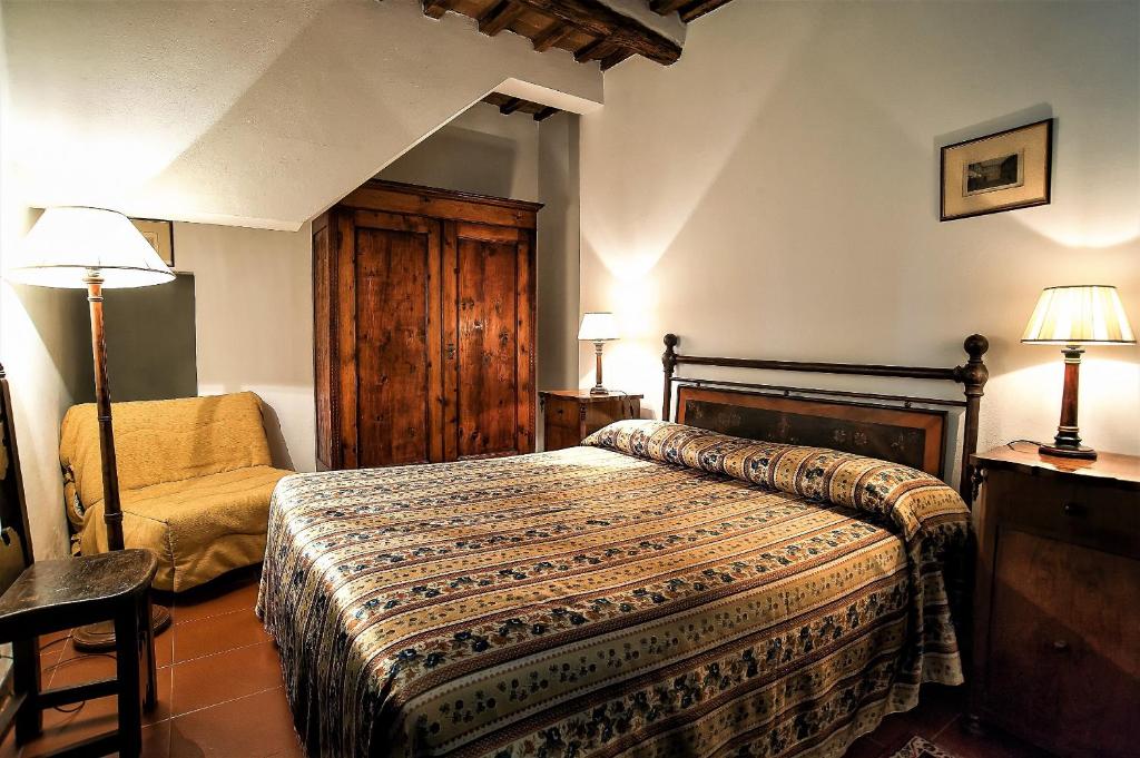Quarto de hotel acolhedor com cama de casal, roupeiro de madeira e poltrona amarela