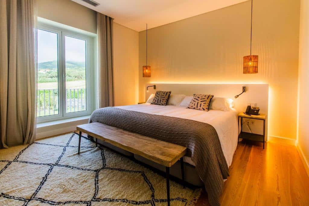 Quarto do SENSI Azores Nature and SPA, com cama de casal e banco aos pés da cama.