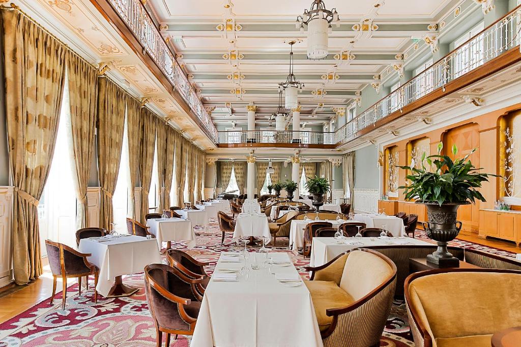 Sala de jantar do Vidago Palace com mesas e cadeiras.