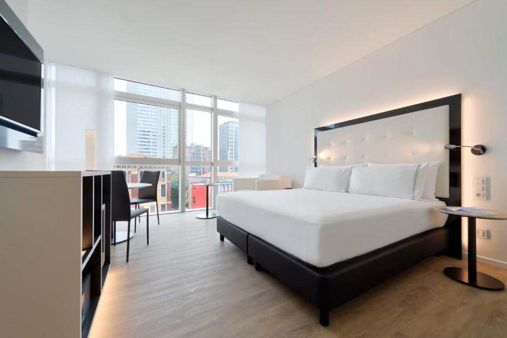 Quarto amplo com secretária, televisão, cama de casal e janela com vista sobre a cidade no INNSiDE by Meliá Milano Torre GalFa