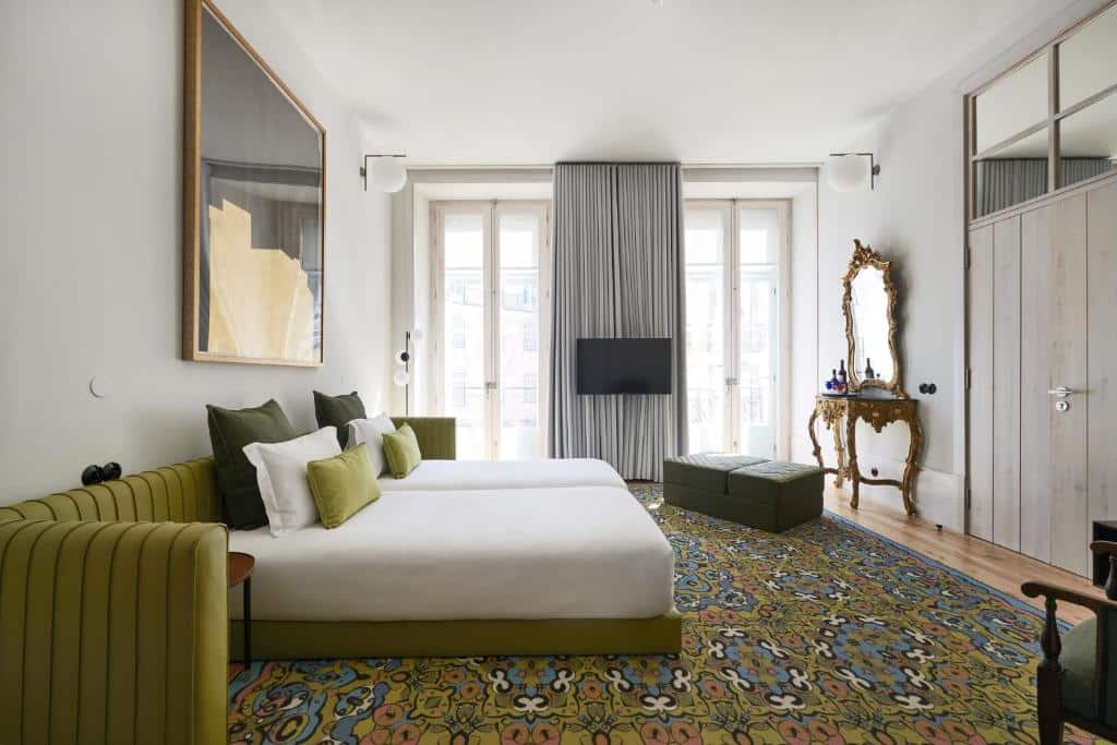 Quarto luxuoso do Cais Urban Lodge com duas camas de solteiro, duas portas para a varanda, uma televisão, poltronas e um toucador de época