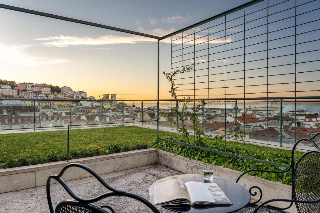 Terraço do Hotel do Chiado com vista para a cidade, rodeado por gradeamento preto e por um jardim