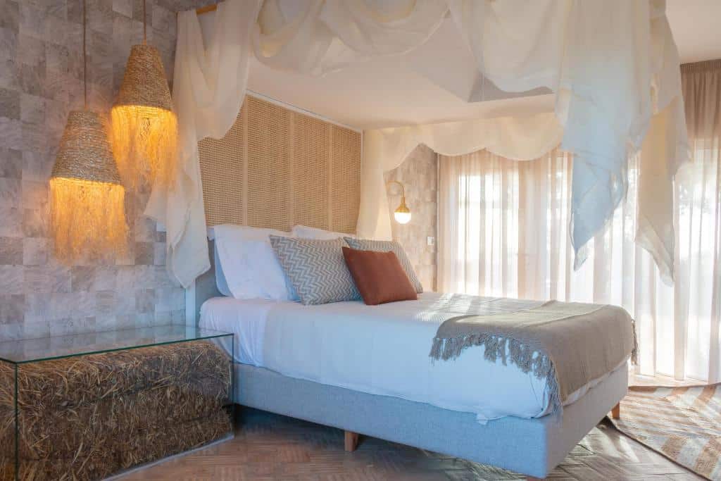Quarto decorado com cama de casal e candeeiros de palha no Reflexos D'Alma Turismo Rural, em Estremoz