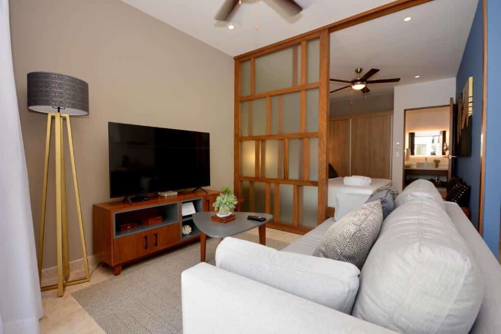 Sala de estar integrada com quarto em suíte no IPANA Luxury Apartments, com TV de ecrã plano.