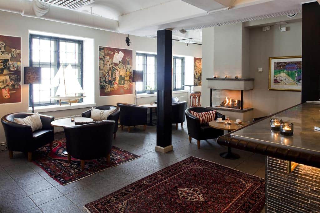 Sala de estar do Långholmen Hotell com poltronas e cadeiras.