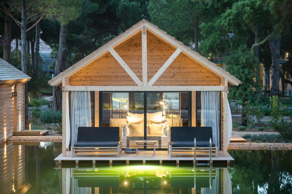 Exterior do Sublime Comporta Country Retreat & SPA com lago em primeiro plano.