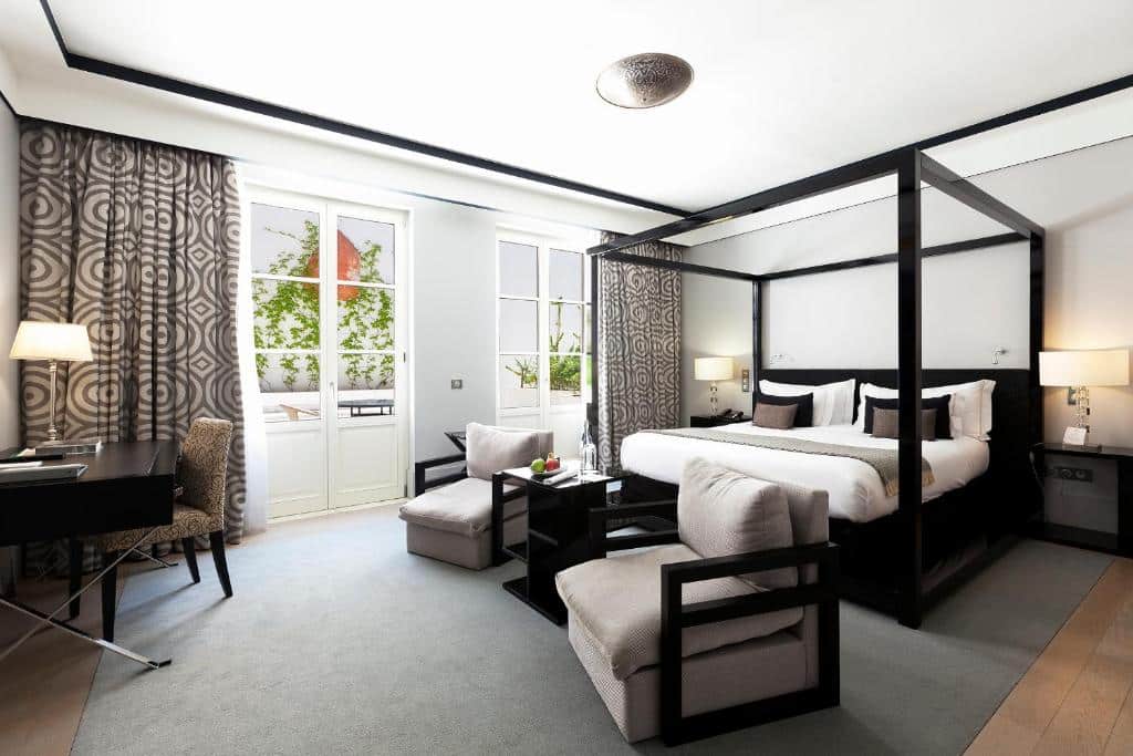 Quarto luxuoso com cama de dossel preta no Alentejo Marmòris Hotel & Spa, em Vila Viçosa