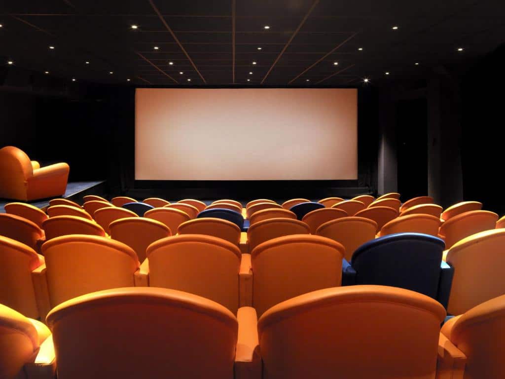 Pequena sala de cinema com poltronas cor de laranja e azuis no Charlotte Street Hotel