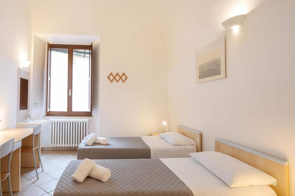 Quarto com duas camas de solteiro, secretária e janela