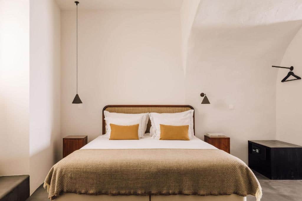 Quarto do White Exclusive Suites & Villas, com cama de casal ao centro e cómodas em madeira.