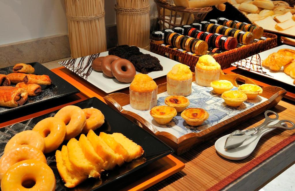 Itens do pequeno-almoço do Vincci Baixa com donuts, pastéis de Belém, bolos e doces