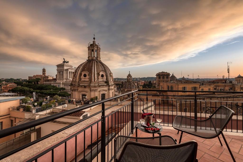 terraço com cadeiras confortáveis e uma mesa com champanhe, com vista para o Fórum Romano, no H10 Palazzo Galla, uma das opções de onde ficar em Roma
