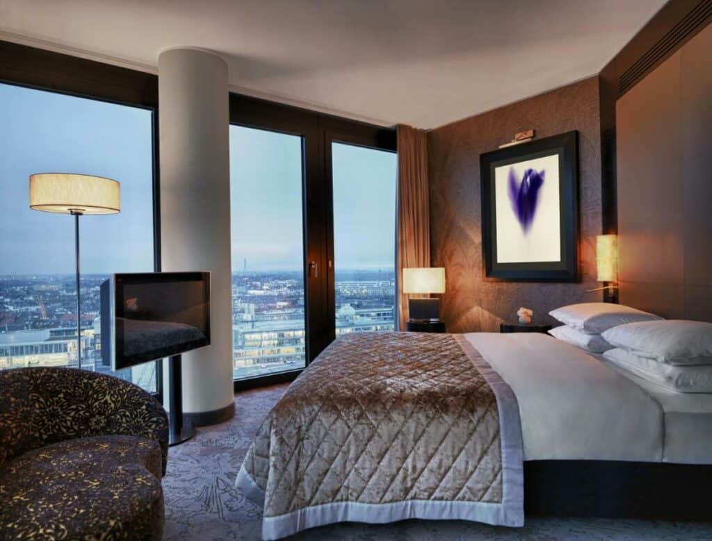 Quarto do Hyatt Regency Dusseldorf com cama de casal e TV em frente. Representa hotéis em Dusseldorf.