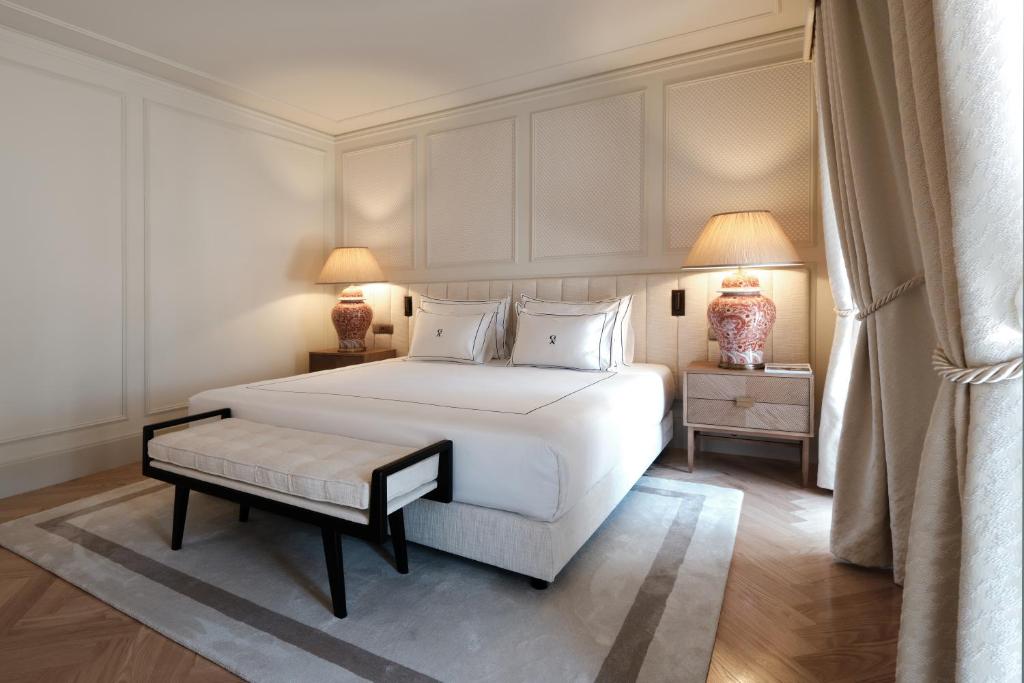 Quarto do GA Palace Hotel, com cama de casal ao centro e banco estofado aos pés da cama.