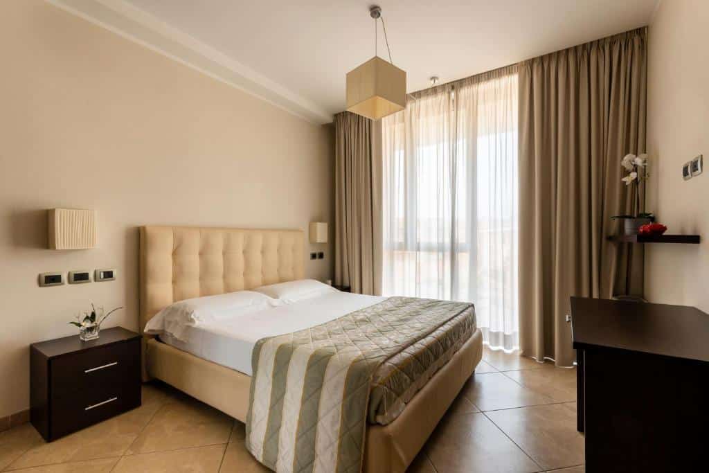 Quarto confortável com cama de casal, secretária e cortinas bege