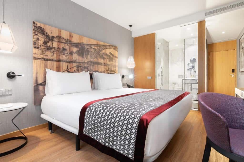 Quarto do Eurostars Porto Centro com cama de casal e, à frente, um cadeirão roxo.