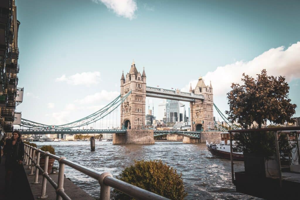 Torre de Londres vista de uma das margens do Rio Tamisa, num dia de céu claro com poucas nuvens