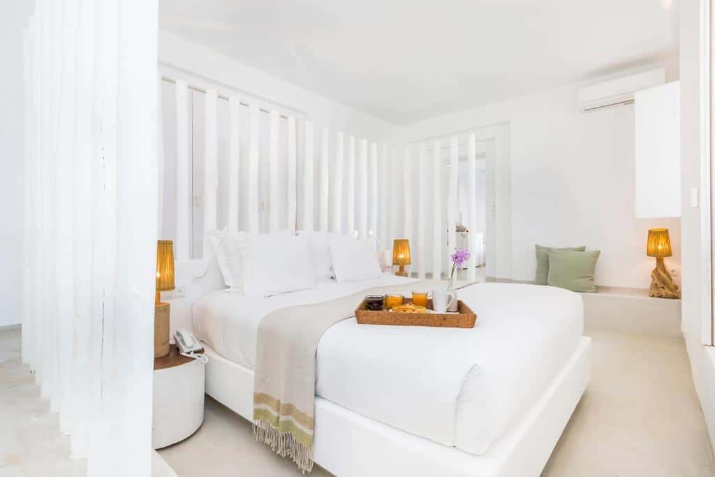 Quarto do Octant Vila Monte com cama de casal e tabuleiro de pequeno-almoço.
