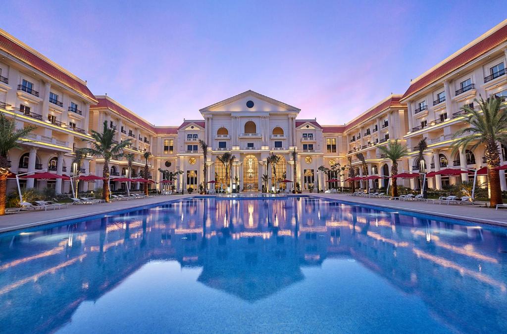 Fachada do The St. Regis Almasa Hotel, no Cairo, com piscina e arquitetura clássica