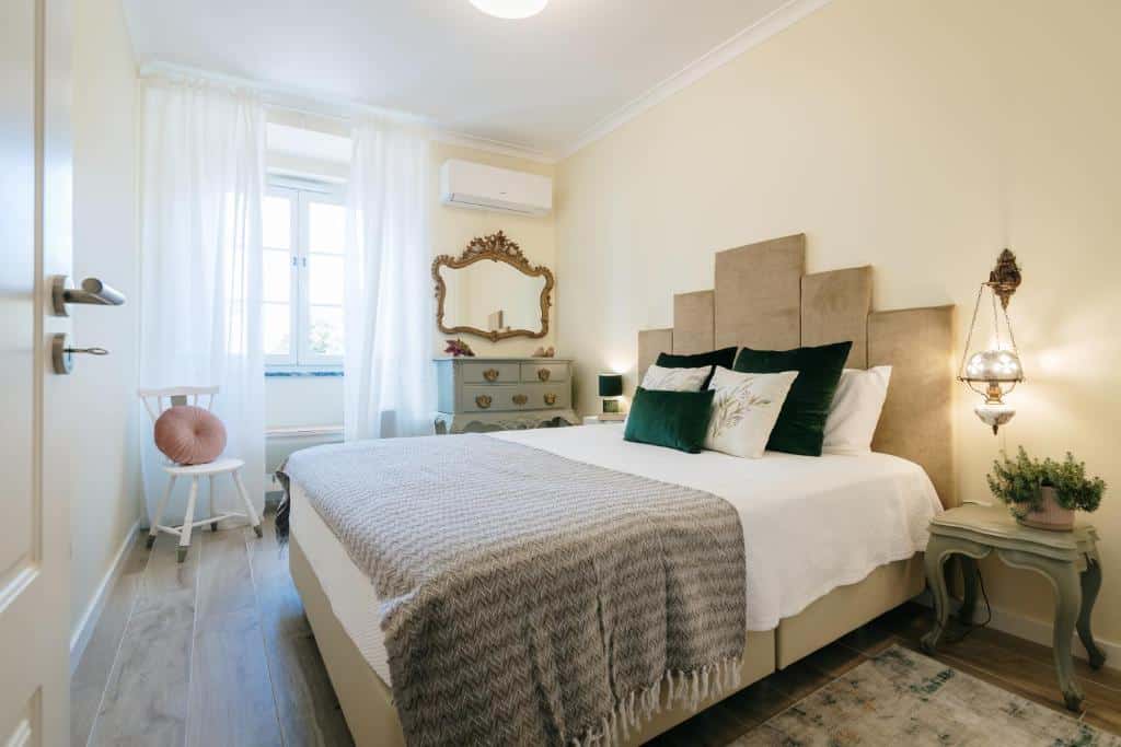 Quarto de casal com roupa de cama cinzenta e verde na Casa Calmaria Beja