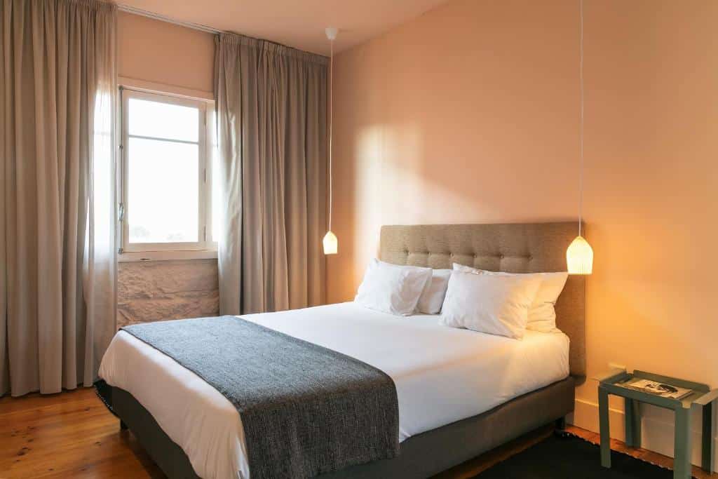 Quarto do Slowly Garden House, com cama de casal à direita e uma cómoda ao lado da cama.