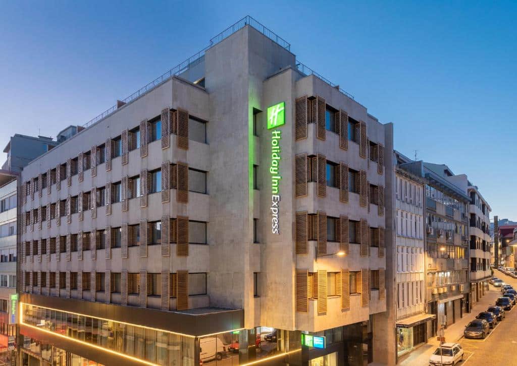 Fachada do Holiday Inn Express Porto City Centre ao fim do dia, com várias janelas.