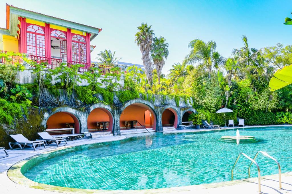 Piscina exterior do Pestana Palace Lisboa Hotel & National Monument, com a unidade ao fundo.