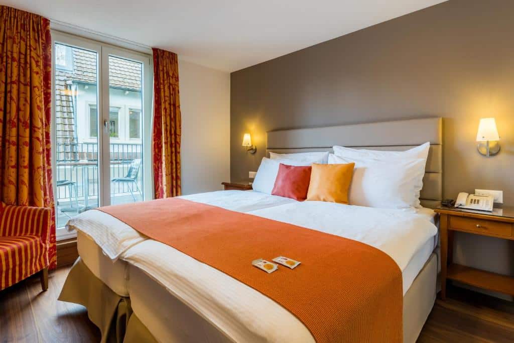 Quarto do Hotel Des Alpes, em Lucerna, com cama de casal e varanda.