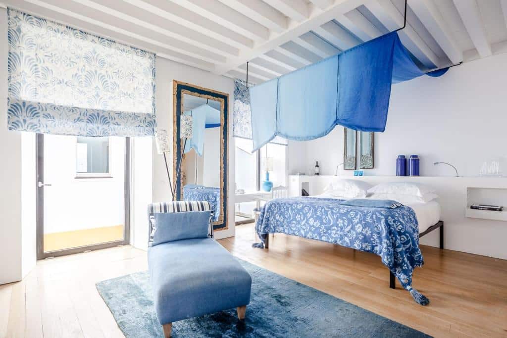 Quarto do Torre de Palma Wine Hotel com cama de casal e poltrona estofada.