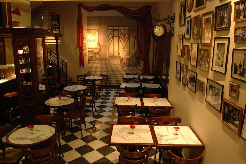 salão temático com mesas e cadeiras de época, chão em xadrez e decoração ao estilo dos anos 50 no Tanguero Hotel Boutique Antique, um dos hotéis românticos em Buenos Aires